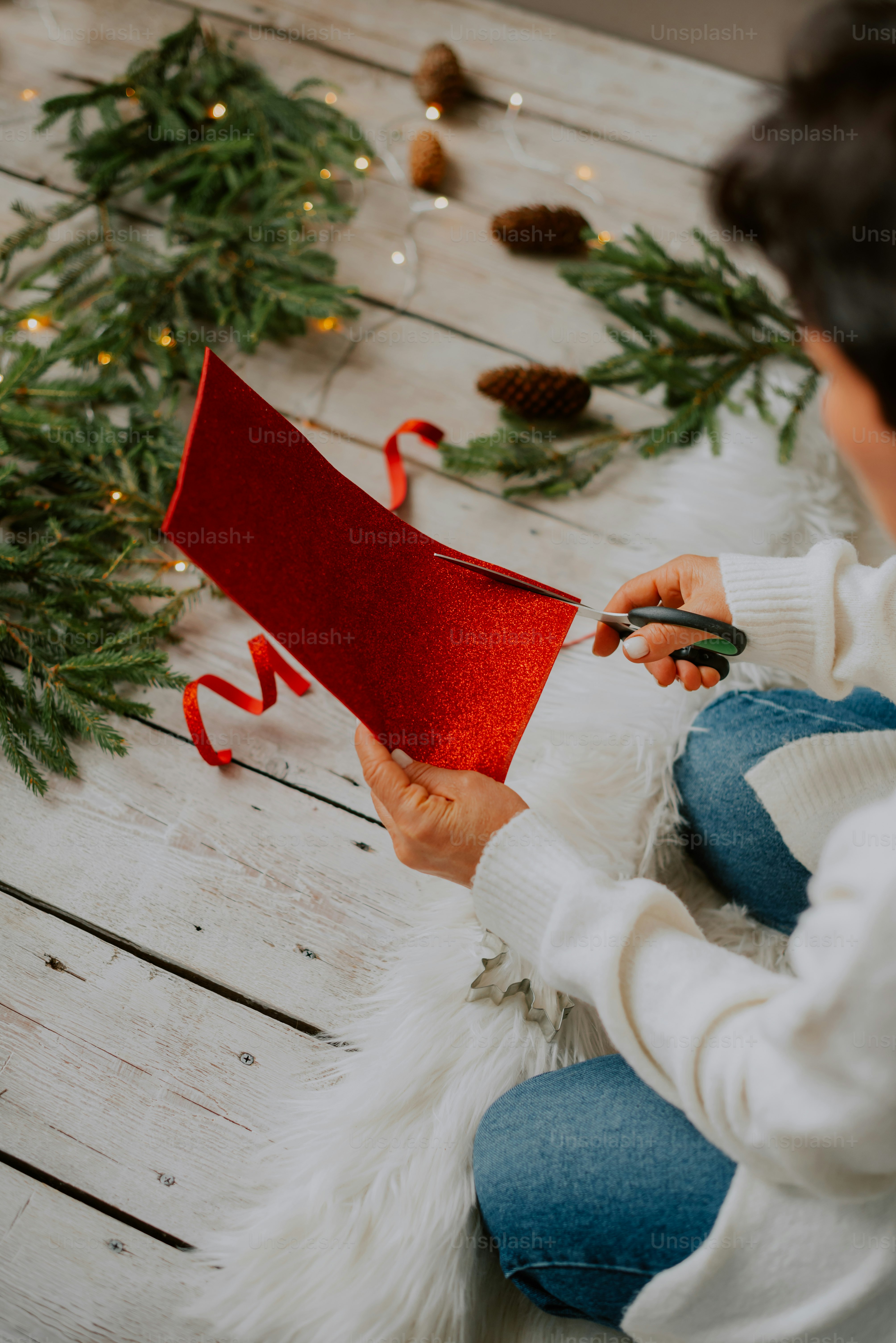 a person sitting on the floor with a red piece of paper