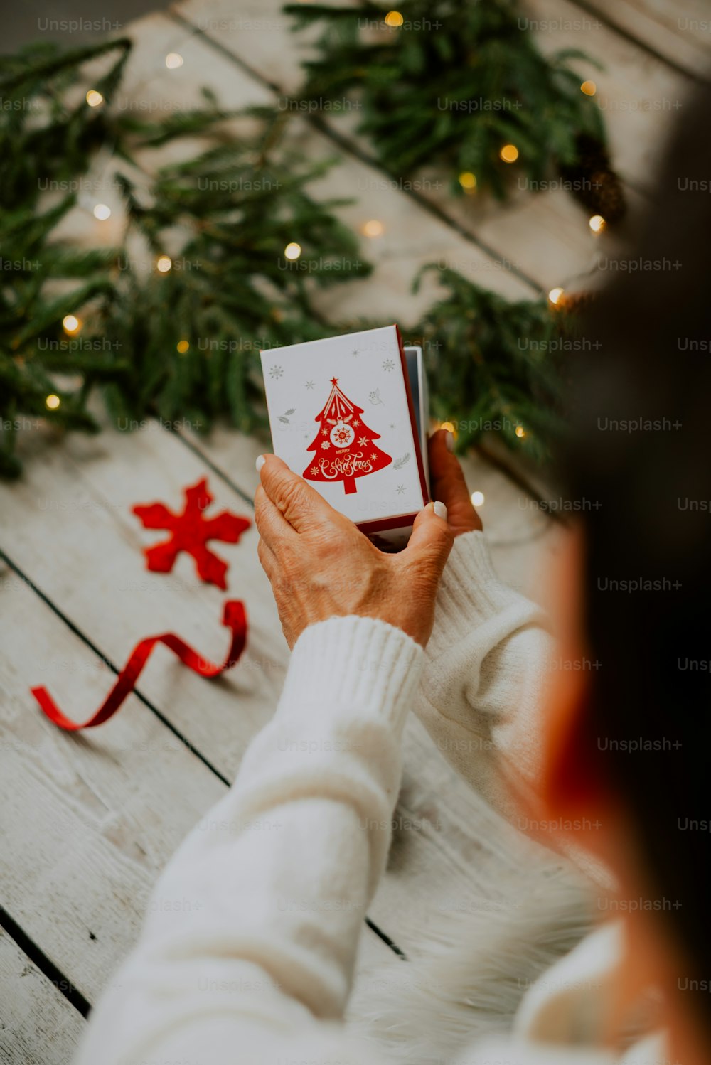 a person holding a card with a christmas tree on it