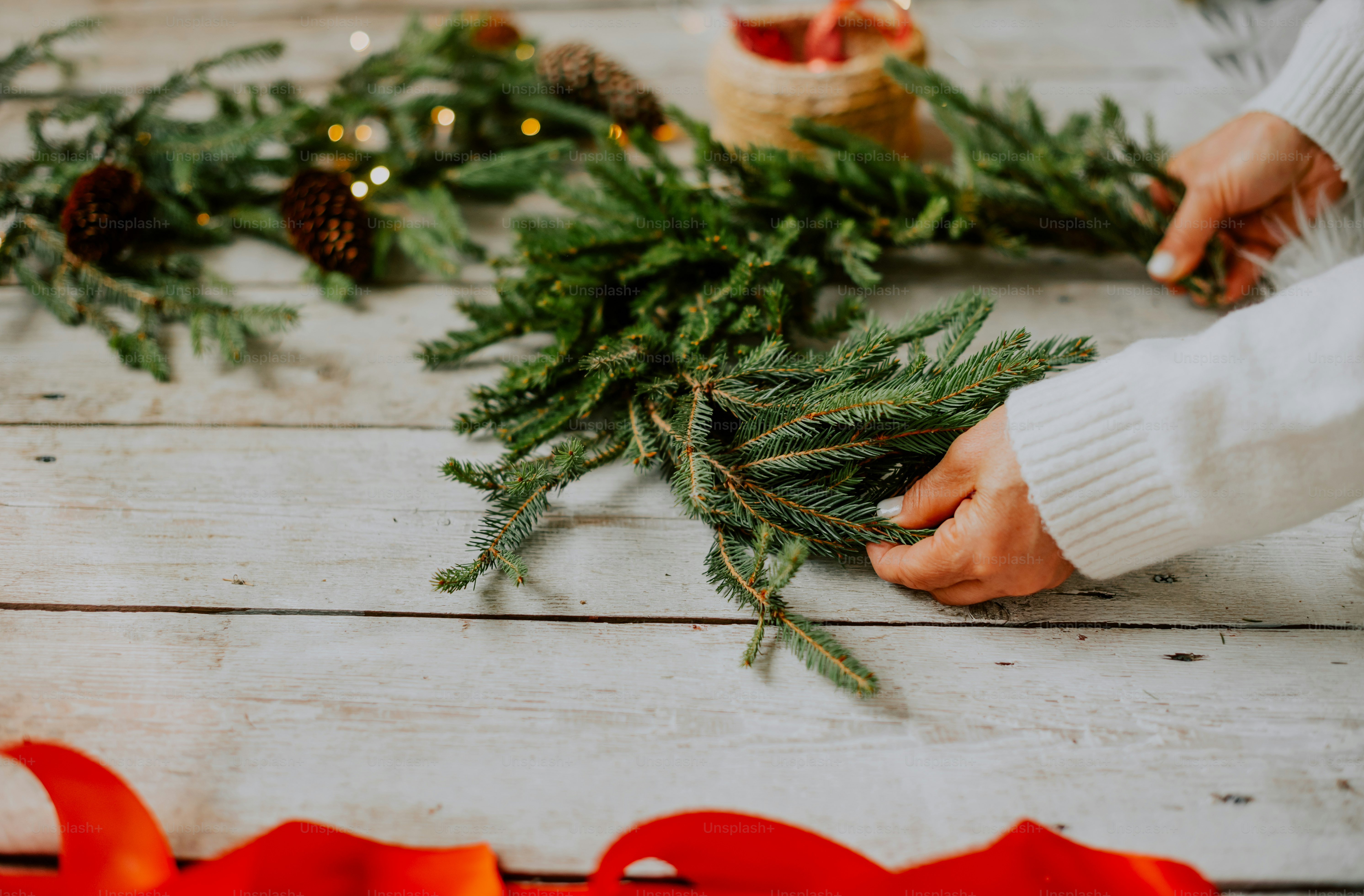 Foto Una persona poniendo un cono de pino encima de una corona de
