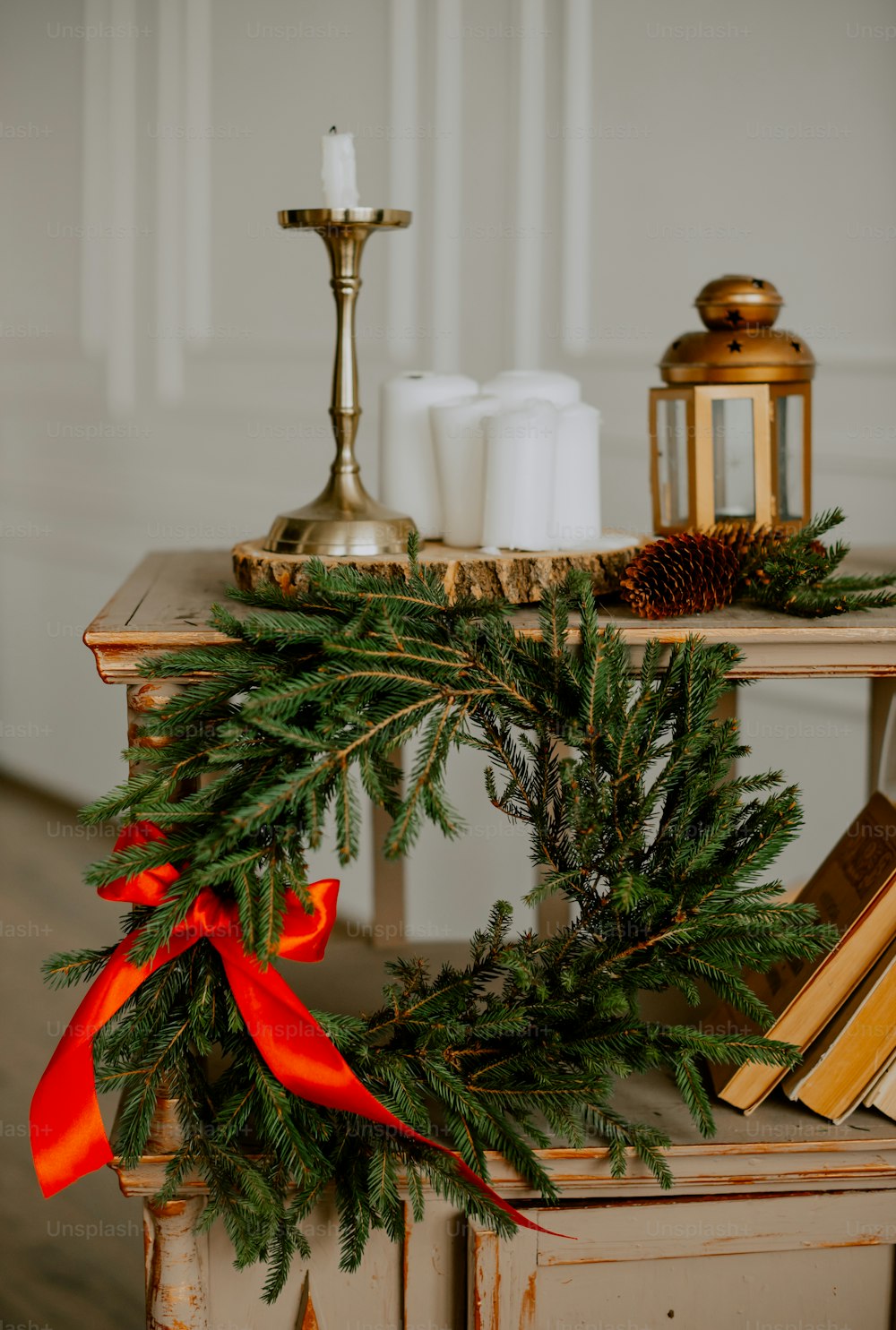 a christmas wreath on a table with candles and a candle holder