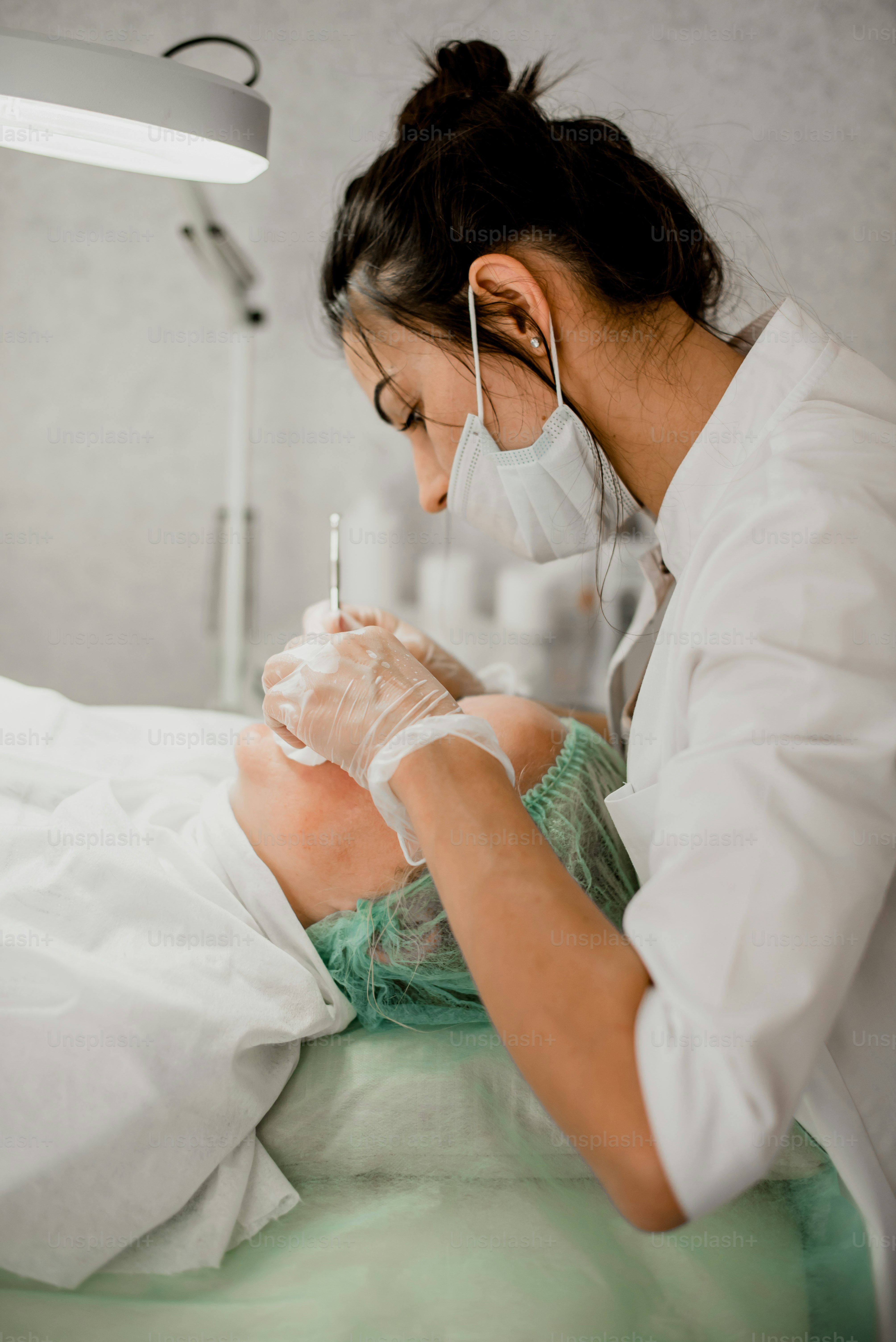 a woman in a hospital gown is getting her teeth checked
