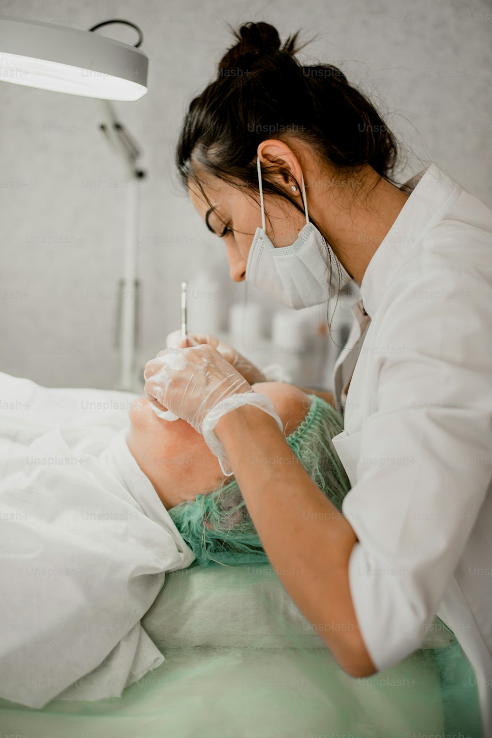 Una mujer con una bata de hospital se está revisando los dientes