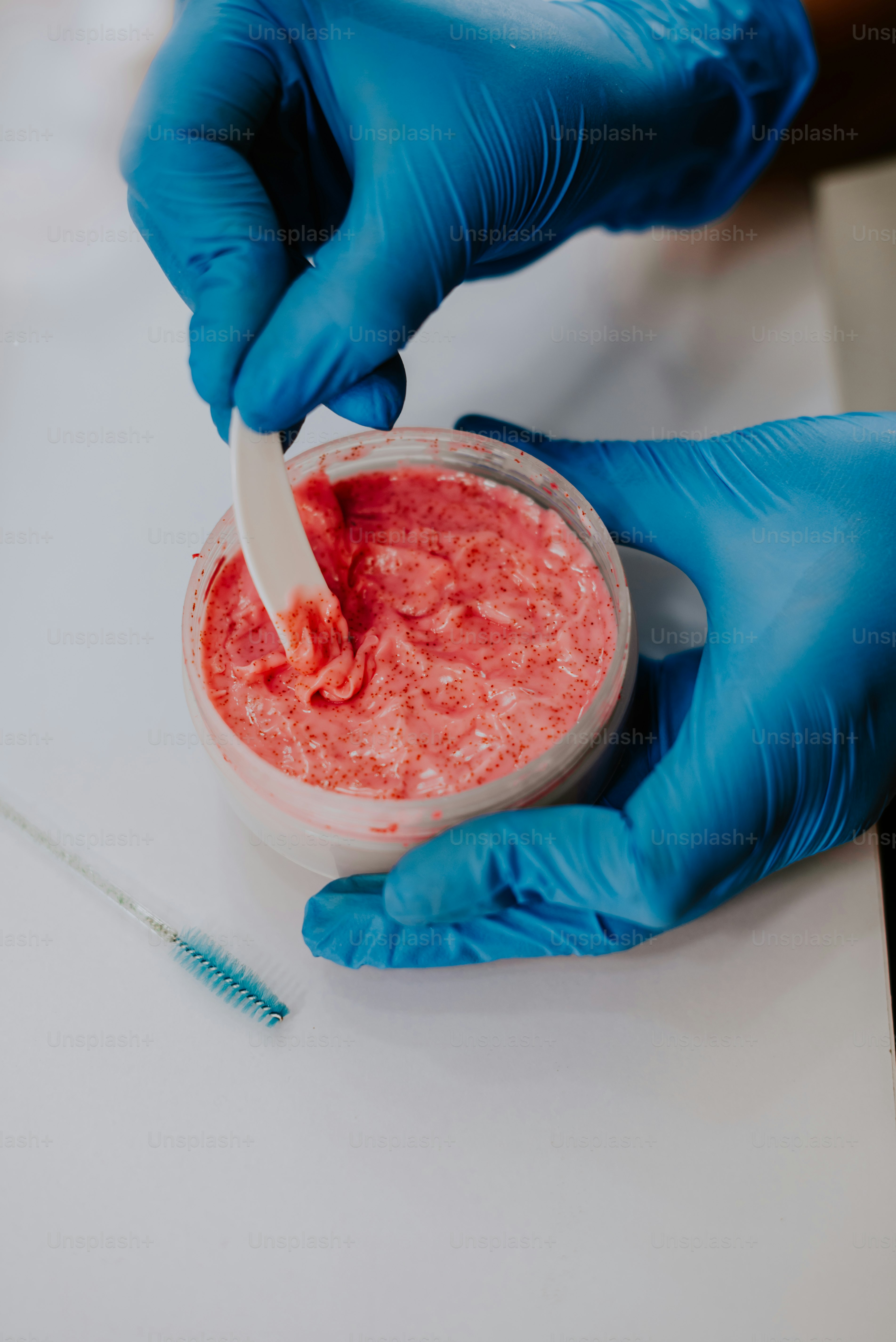 a person in blue gloves is putting something in a container