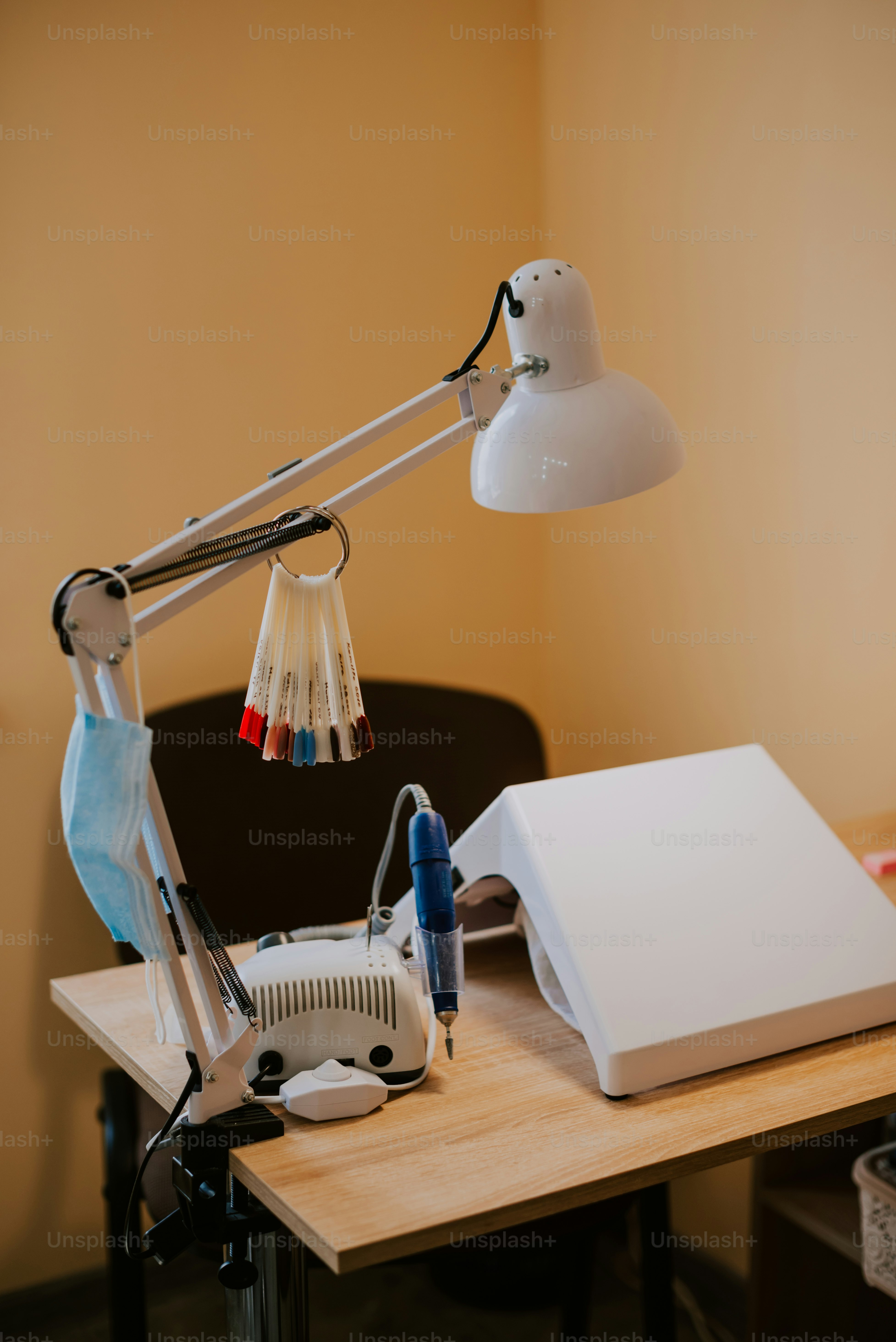 a desk with a lamp and a laptop on it