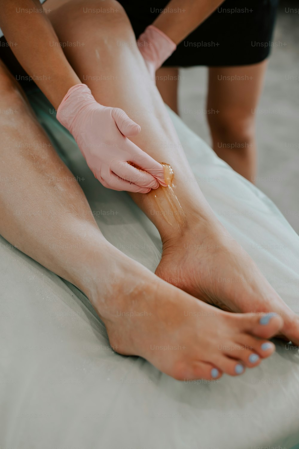 a person getting a foot rub with a rubber glove