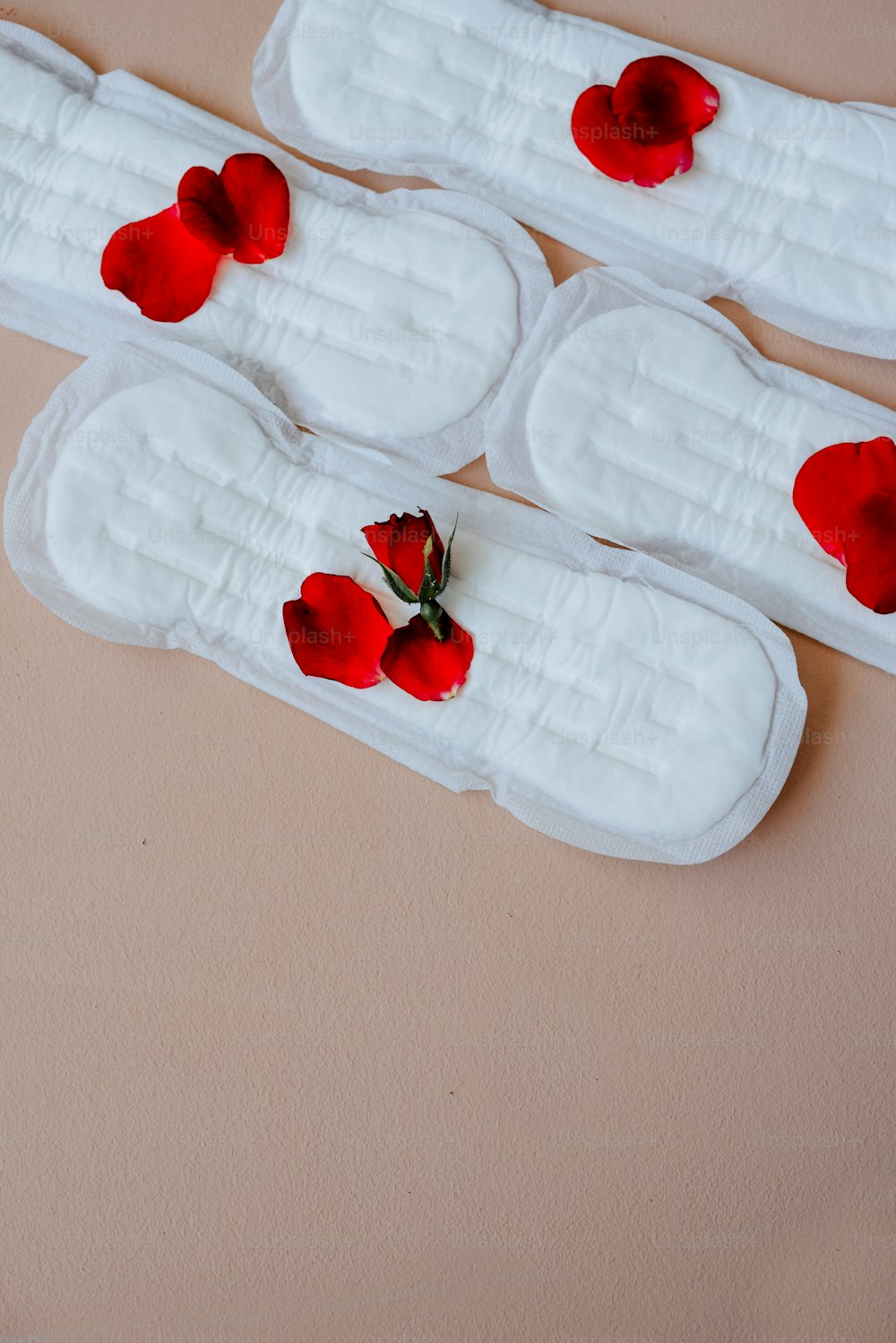 four pieces of white cake with red flowers on them