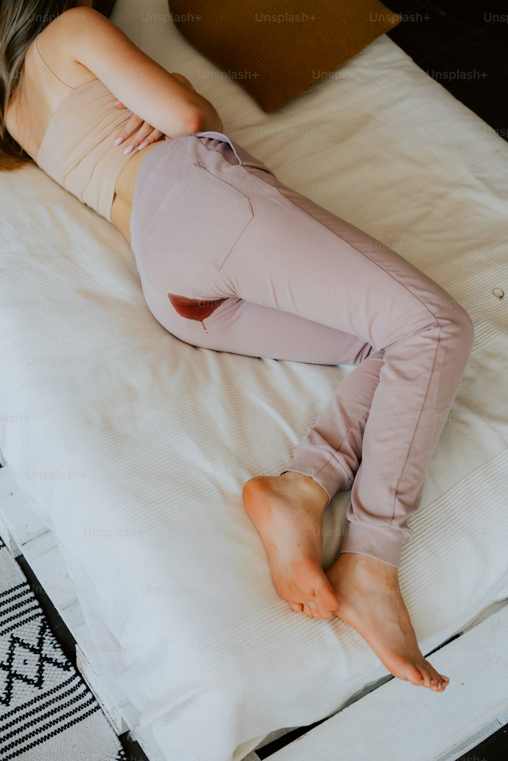 a woman laying on top of a white bed