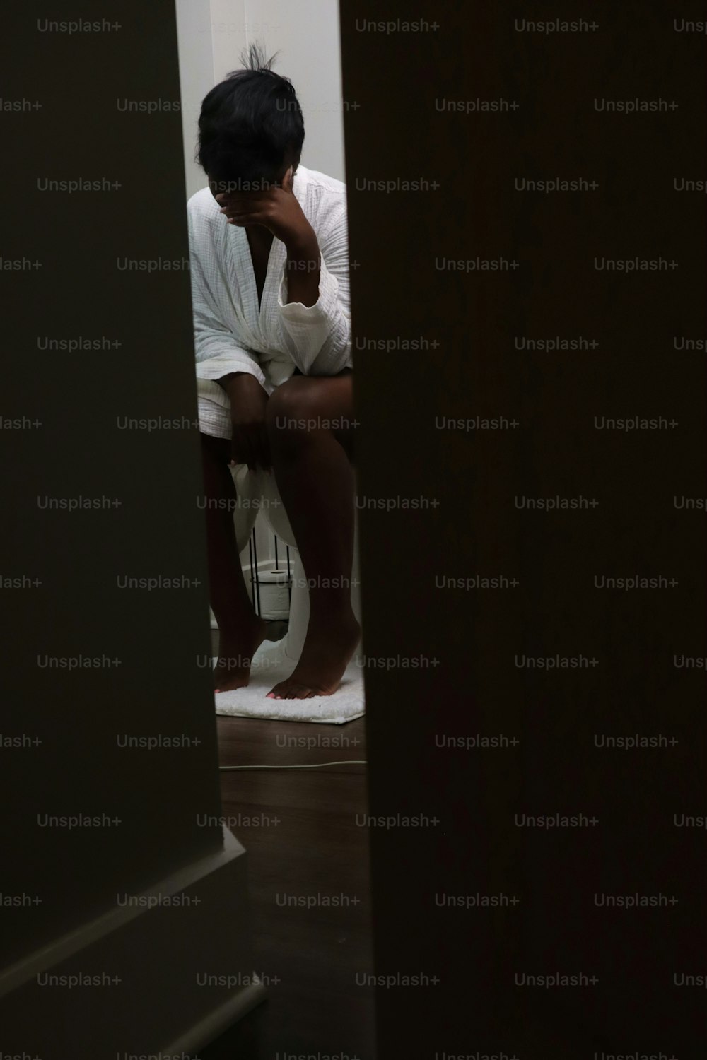 una persona seduta su un gabinetto in una stanza