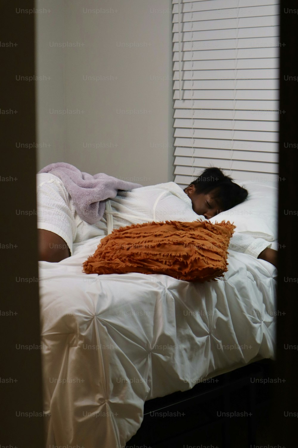 une personne allongée dans un lit avec une couverture dessus