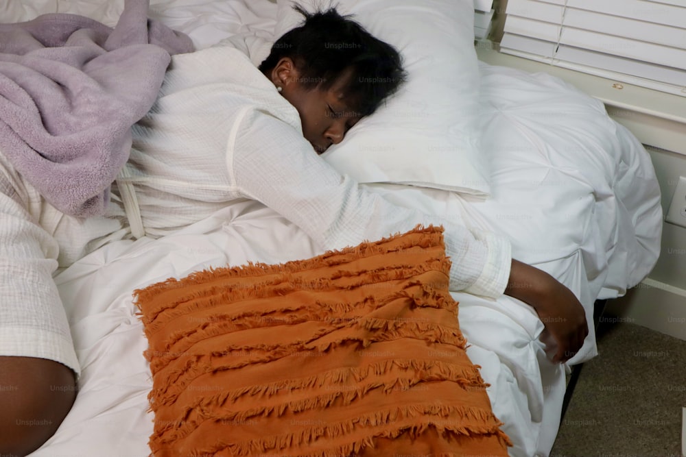 uma mulher dormindo em uma cama com um travesseiro