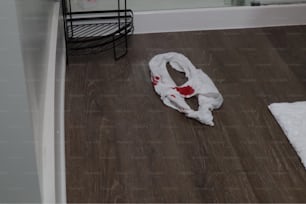 a white towel on the floor of a bathroom