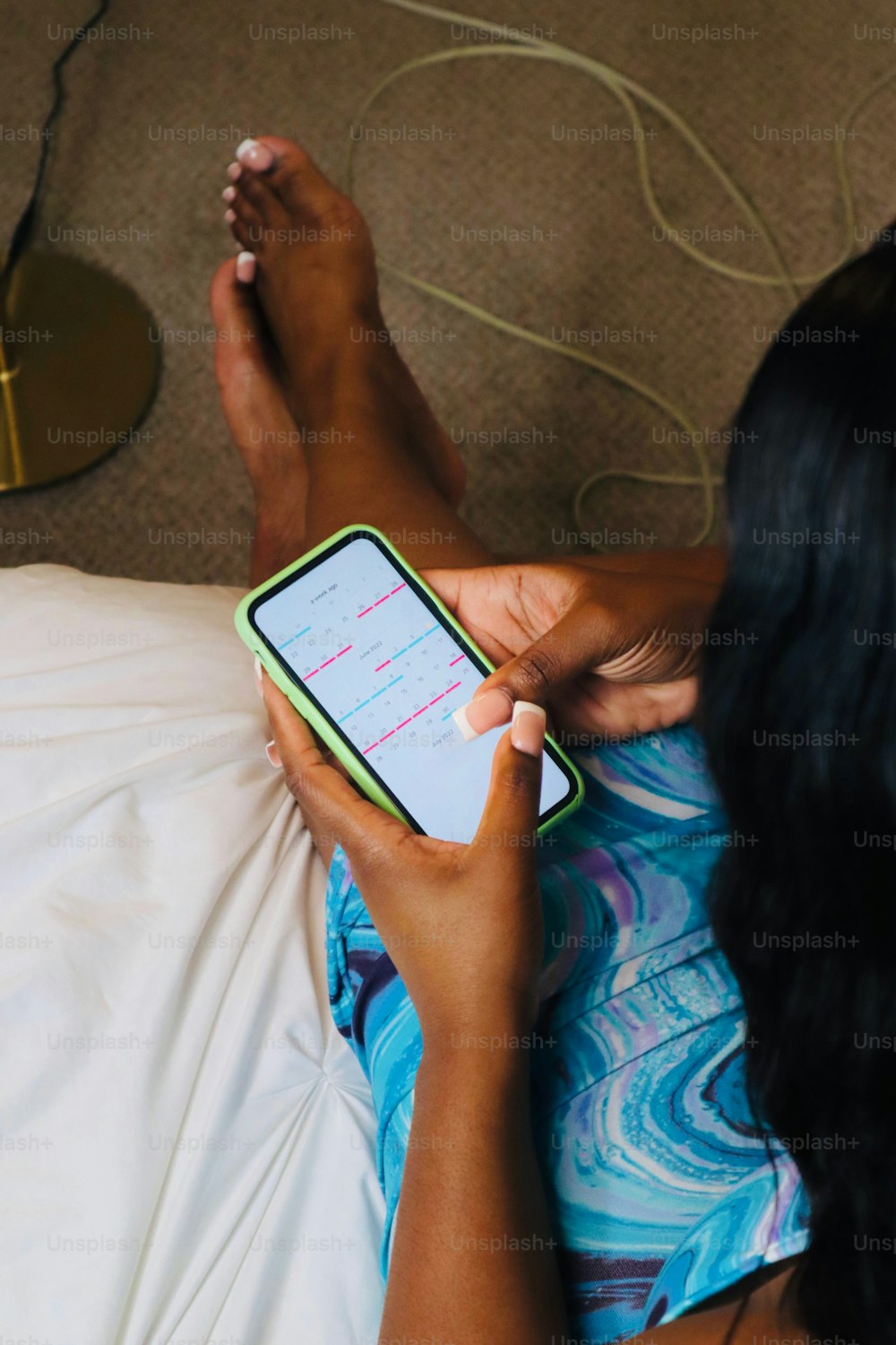 a woman laying on a bed holding a cell phone