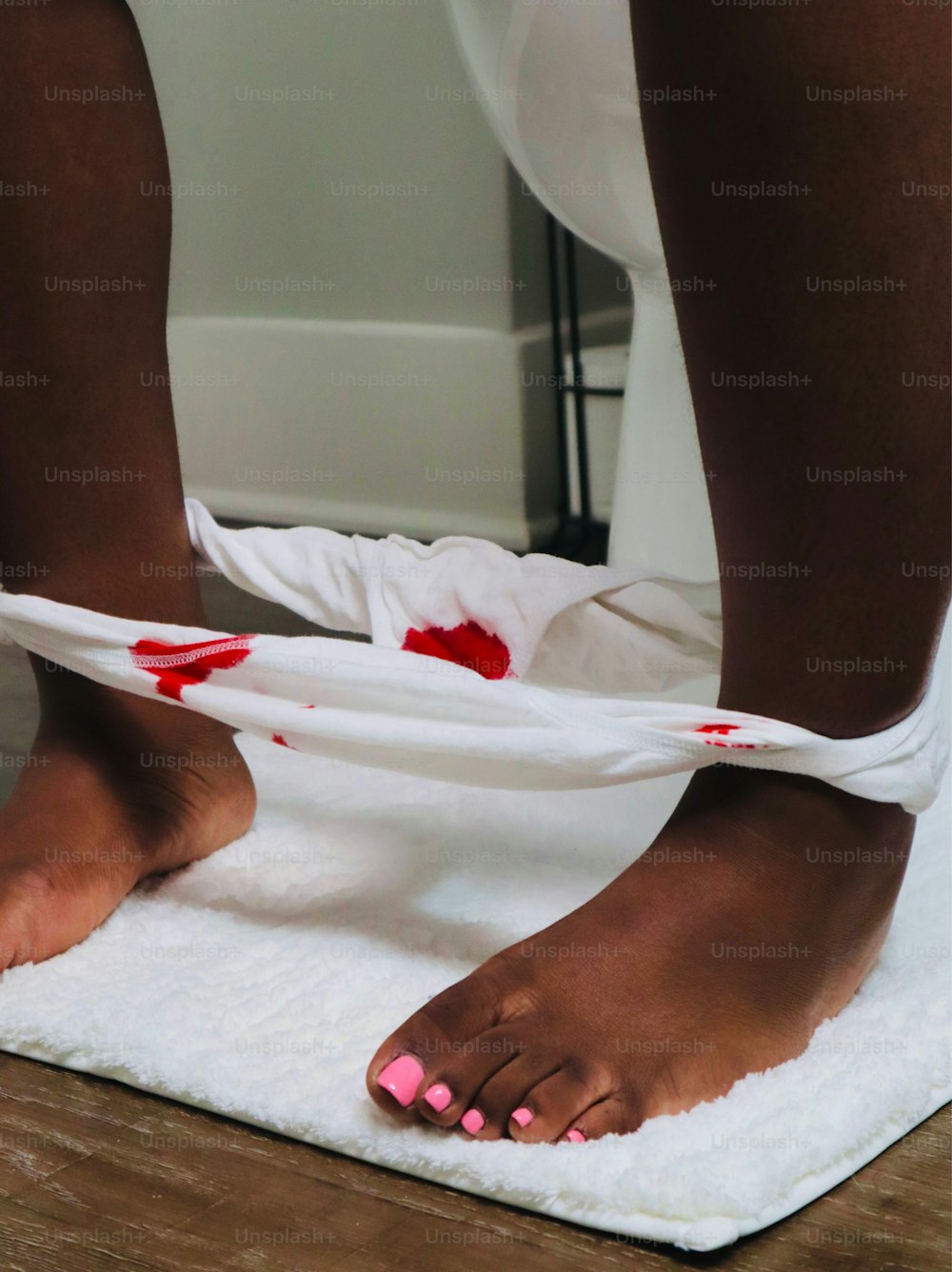 una persona con sangue sui piedi su un asciugamano