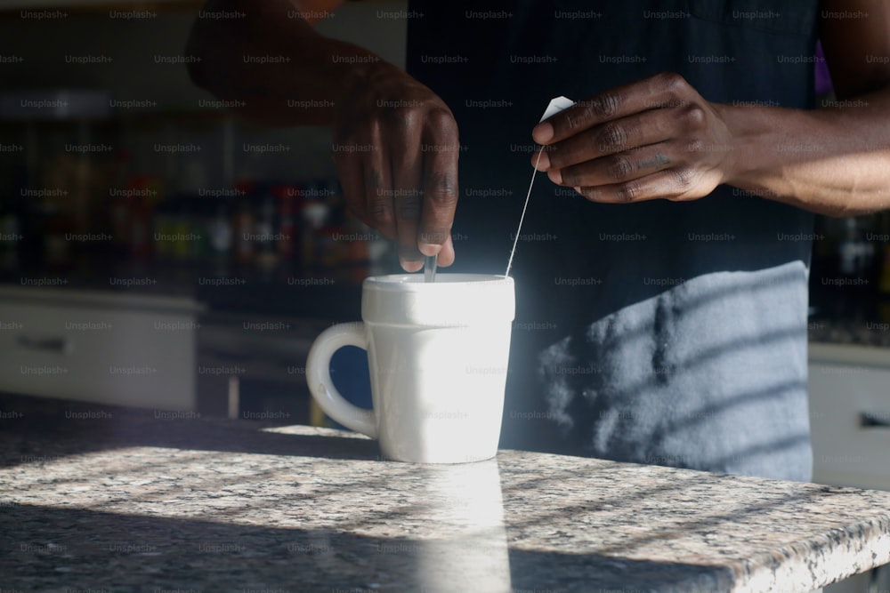 a person putting something in a cup on a counter