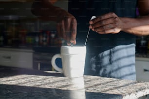 a person putting something in a cup on a counter