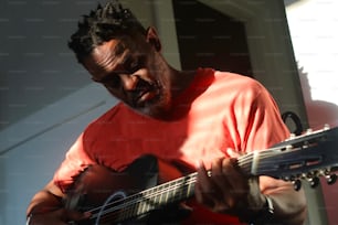 a man with dreadlocks playing a guitar