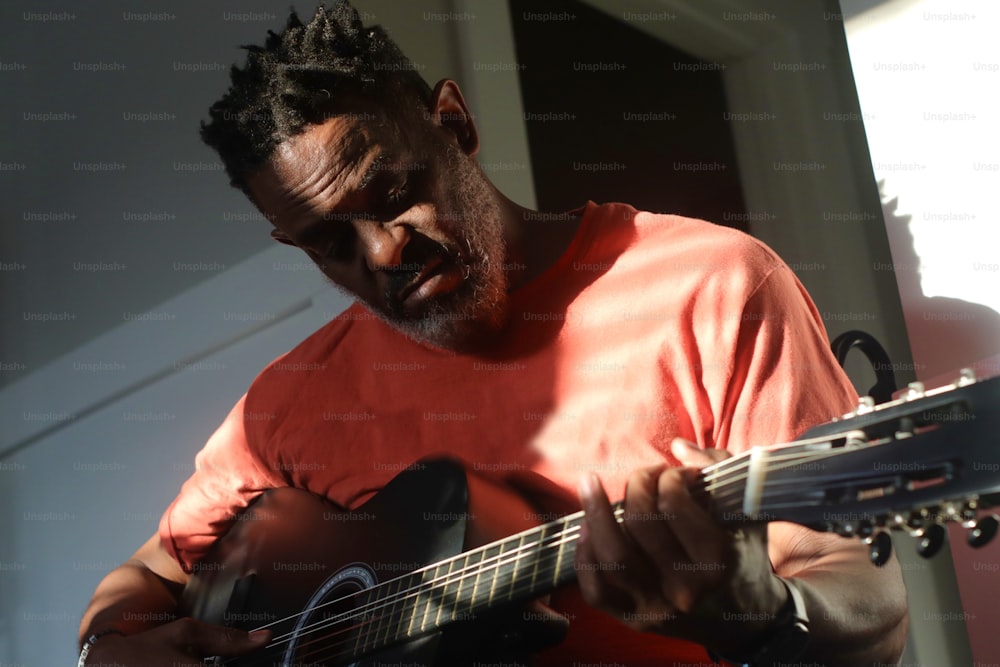 Un hombre con rastas tocando una guitarra