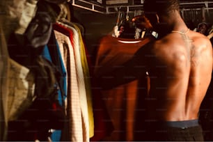 a man standing in front of a rack of shirts