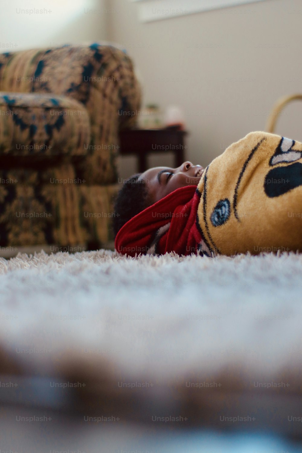 a small child laying on the floor with a stuffed animal