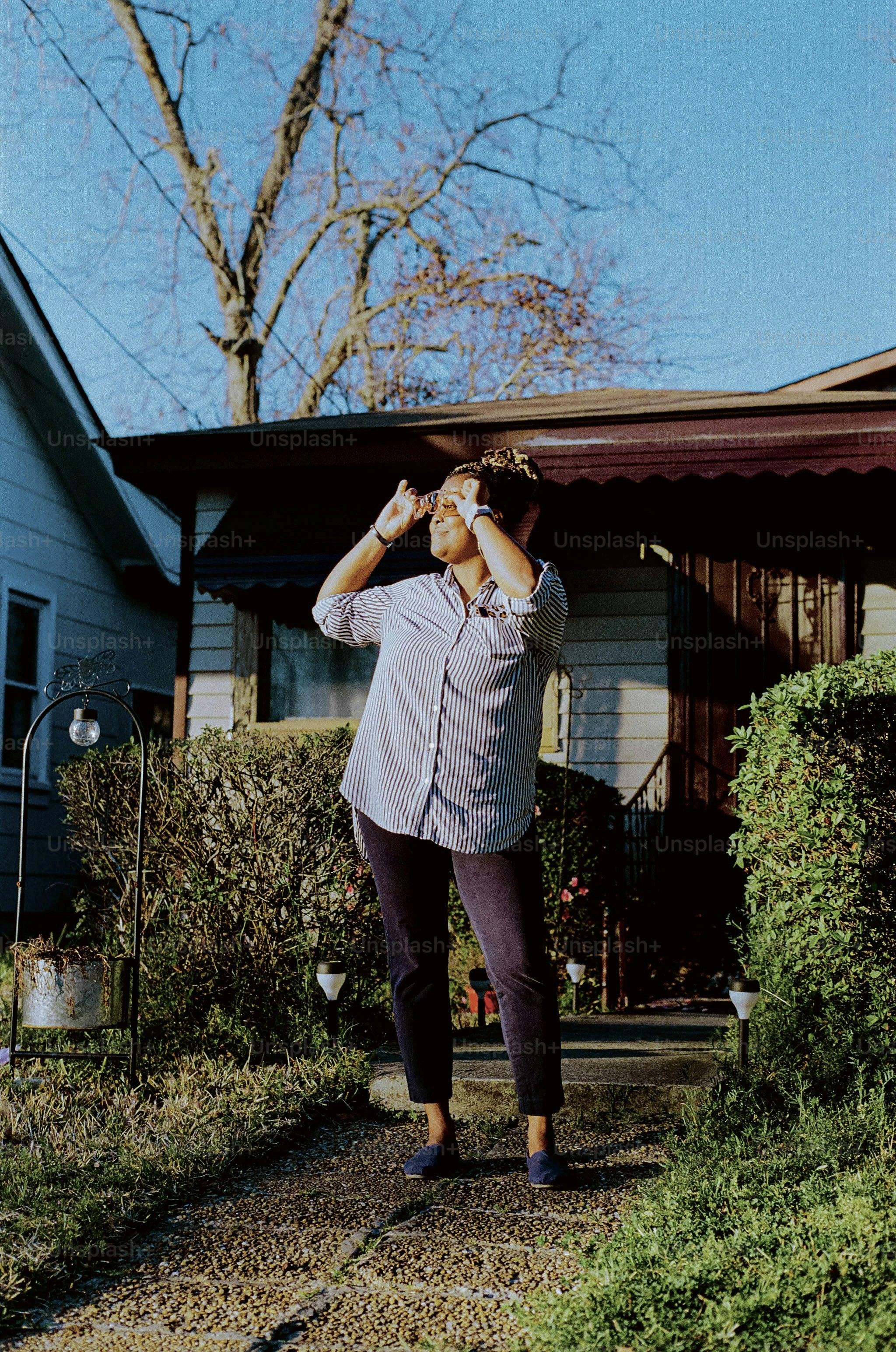 a woman standing in front of a blue house