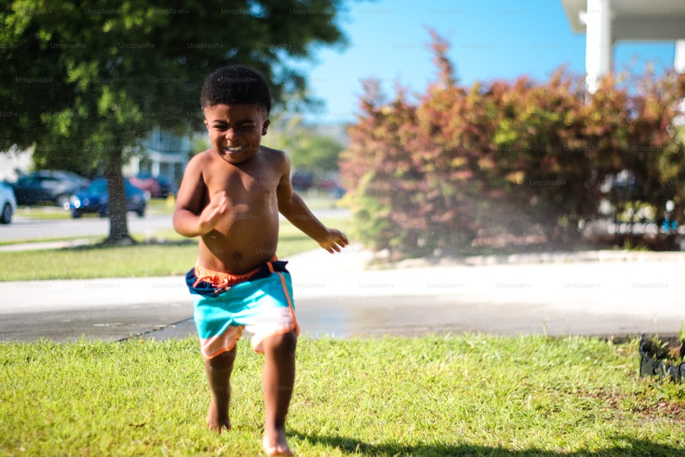 a young boy playing with a frisbee in a yard