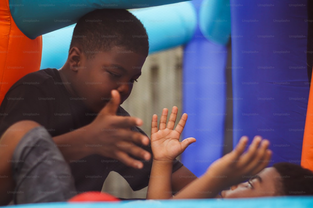 a boy and a girl playing in a bouncy house
