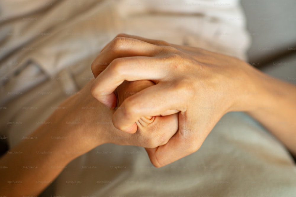 um close up da mão de uma pessoa em uma cama