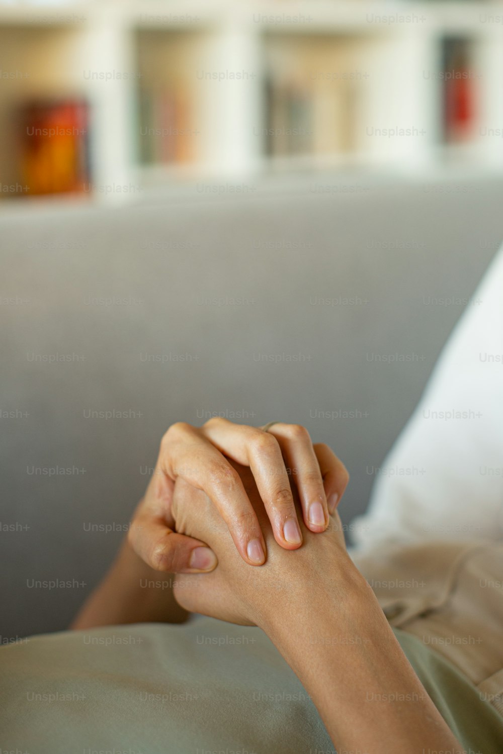 a person laying on a couch with their hand resting on the pillow