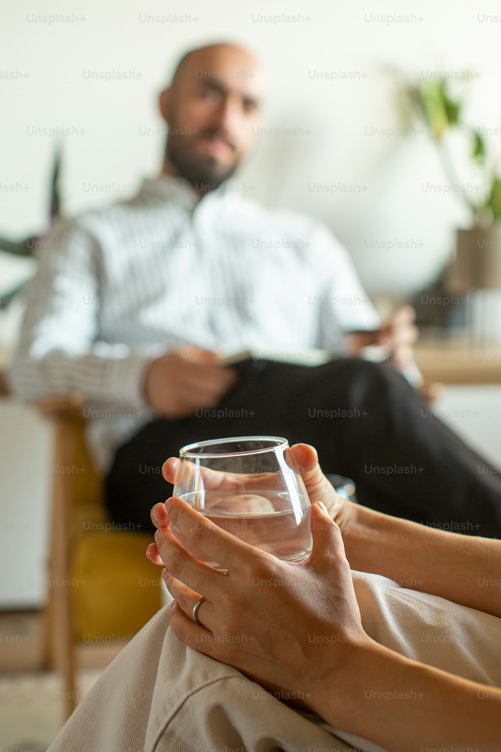 한 남자와 한 여자가 물 한 잔을 들고 소파에 앉아 있다