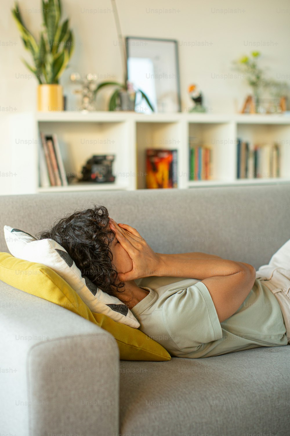 a man laying on top of a couch under a blanket