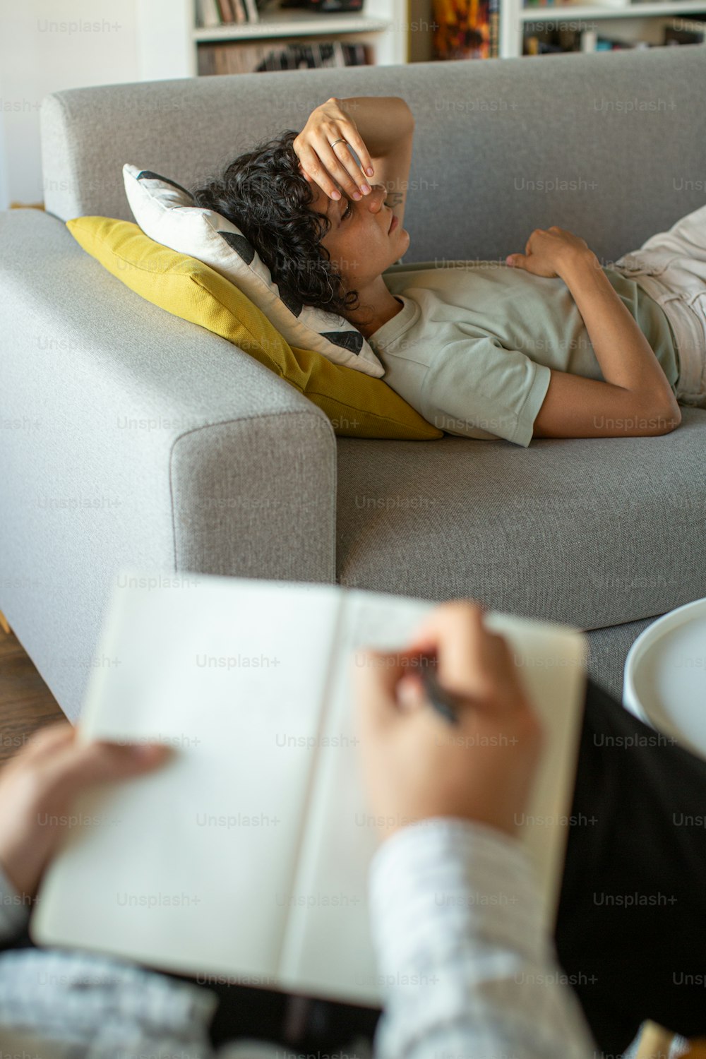 una persona sdraiata su un divano con un libro