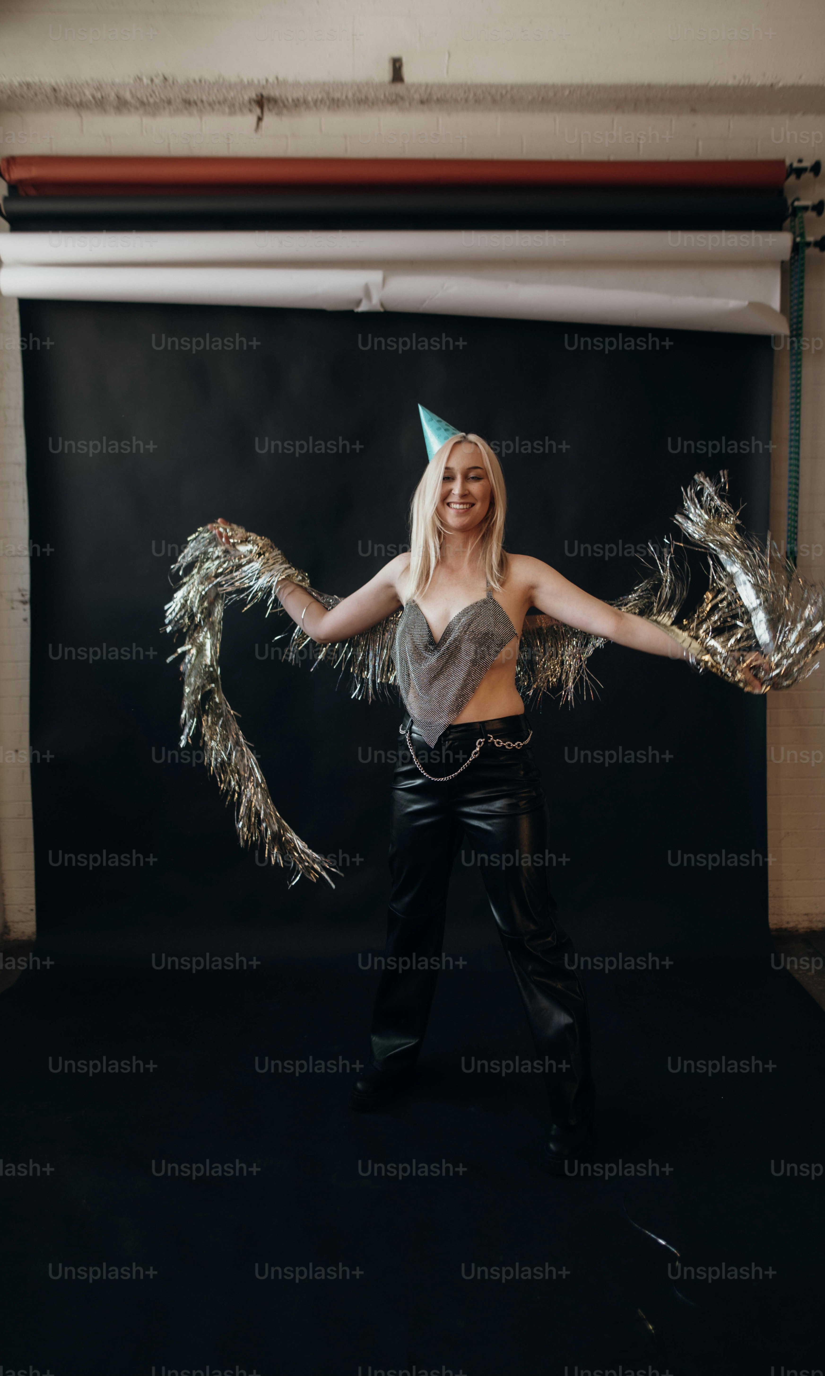 シルバーのトップスと黒いズボンの女性