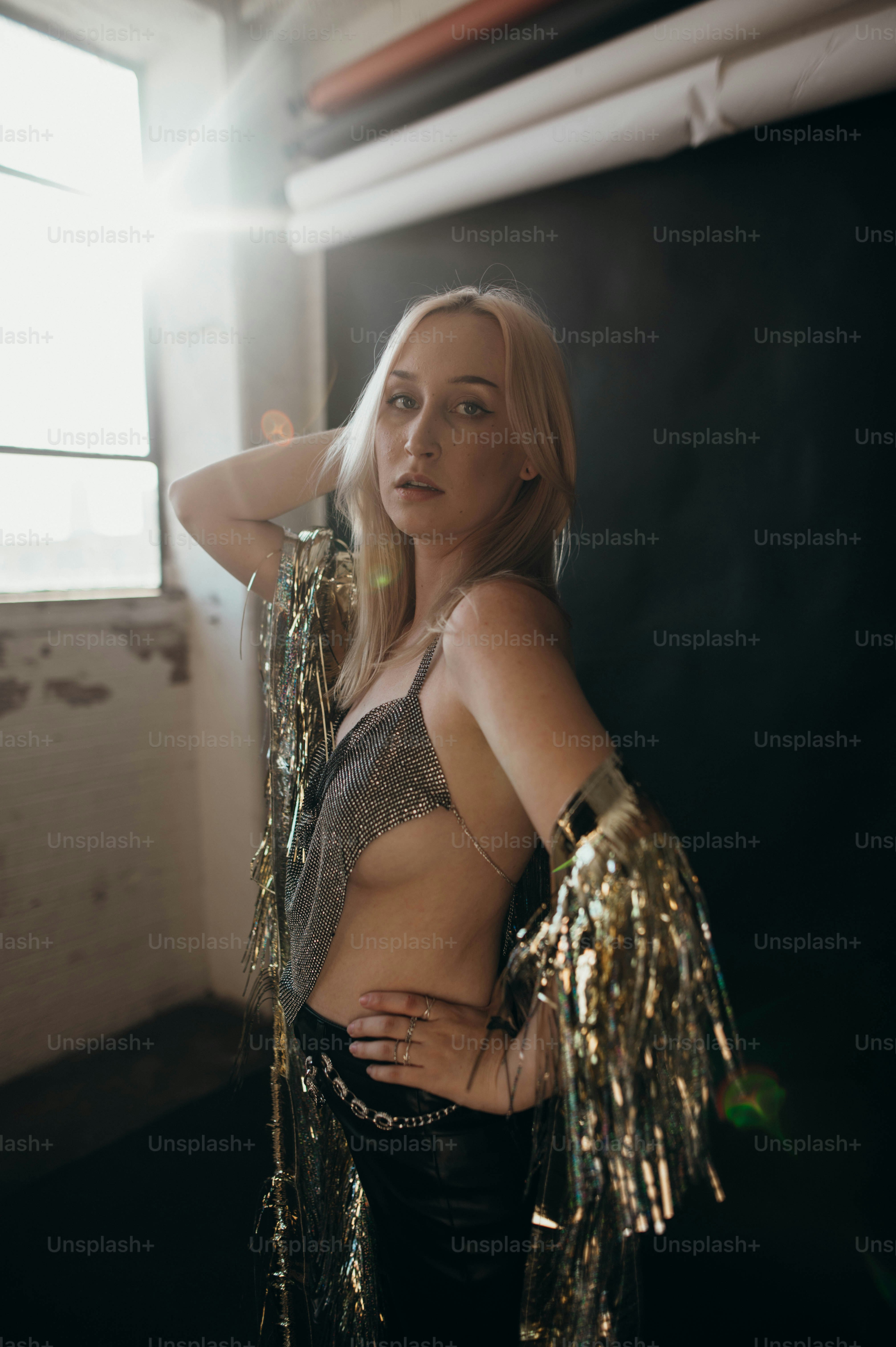 銀色のトップを着た女性が写真のポーズをとっている