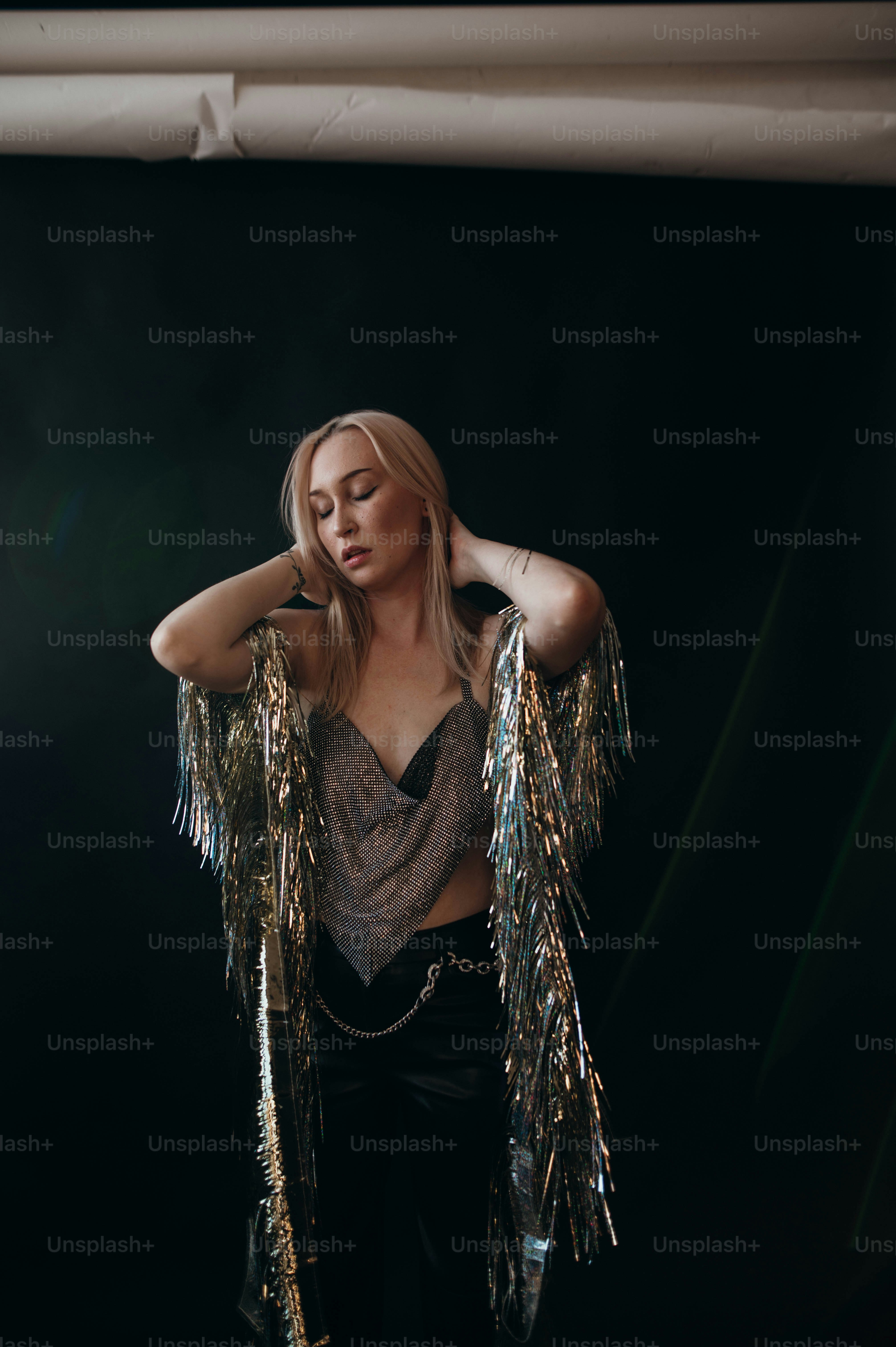 a woman in a silver top and black pants