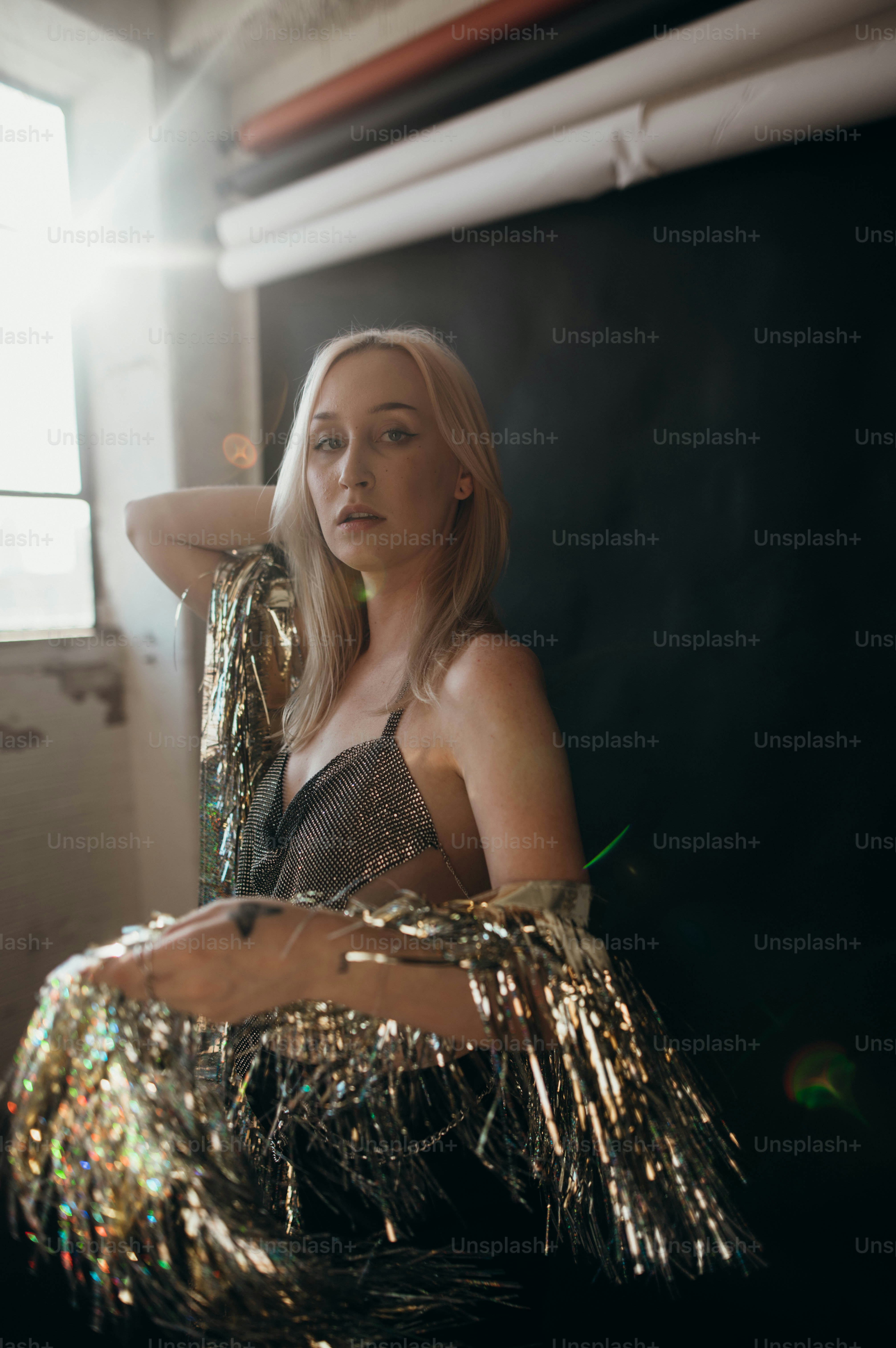 a woman in a silver dress sitting on a chair