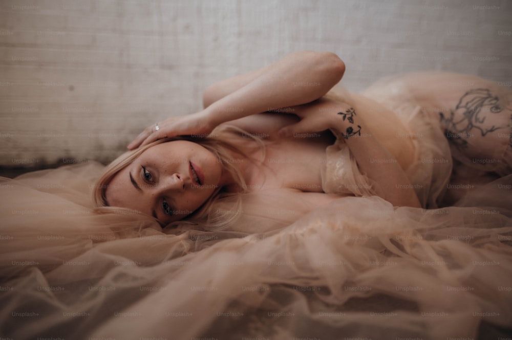 una donna sdraiata sopra un letto che indossa un vestito