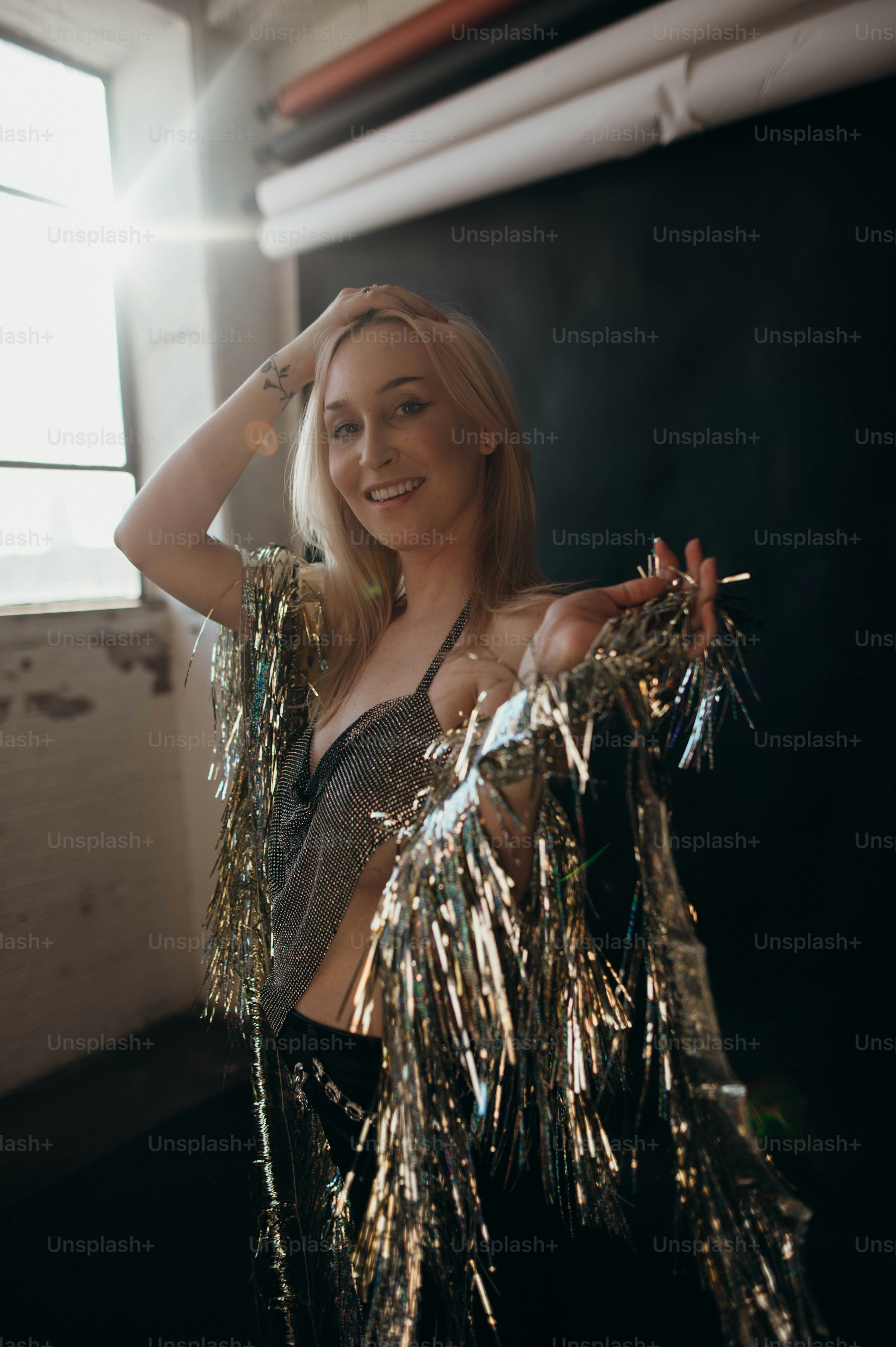 a woman in a silver top is posing for a picture
