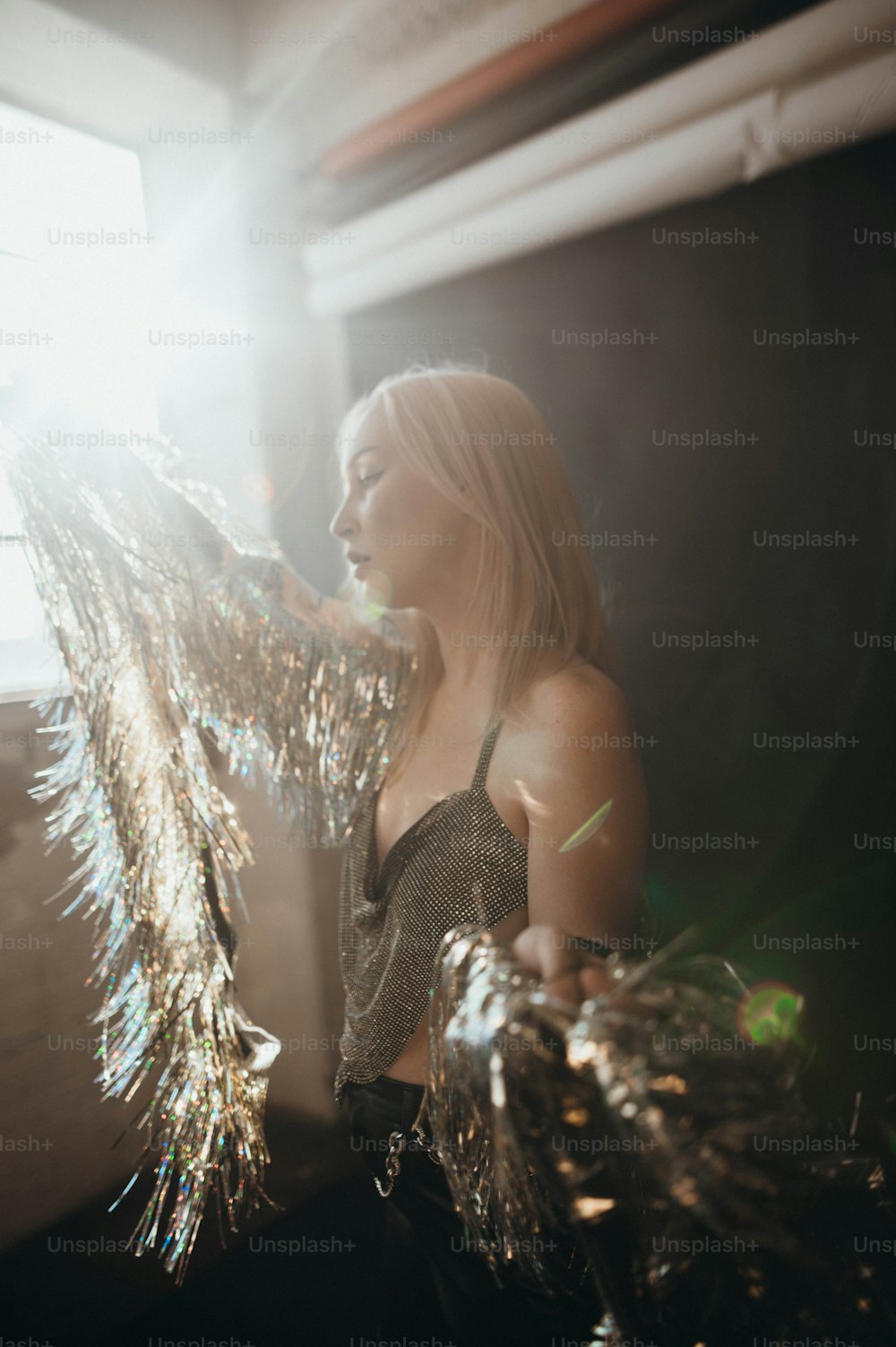 a woman standing in a room holding a bunch of tinsel