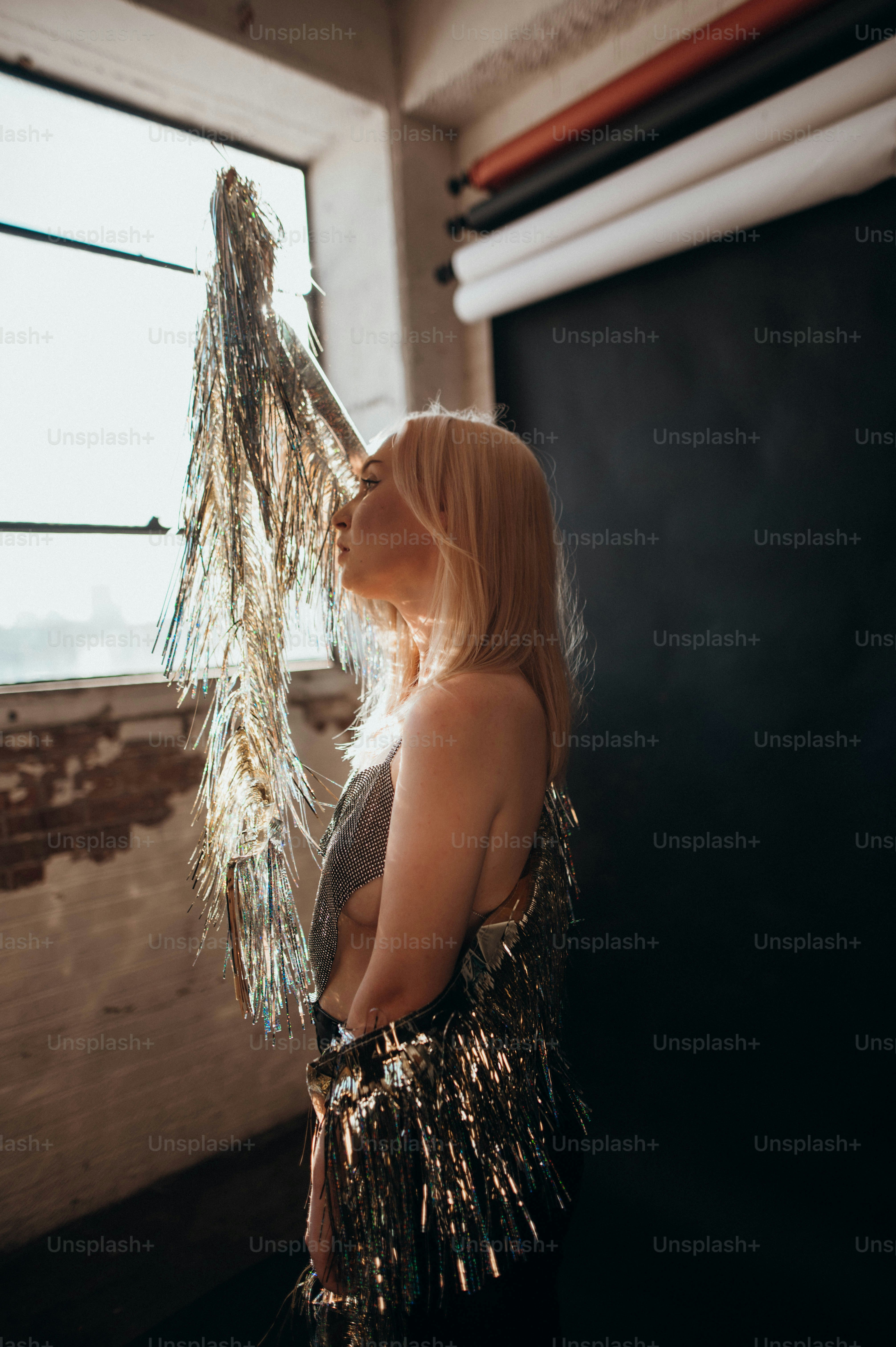 a woman standing in front of a window holding a bunch of tinsel