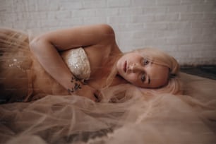 a woman laying on a bed with a dress on