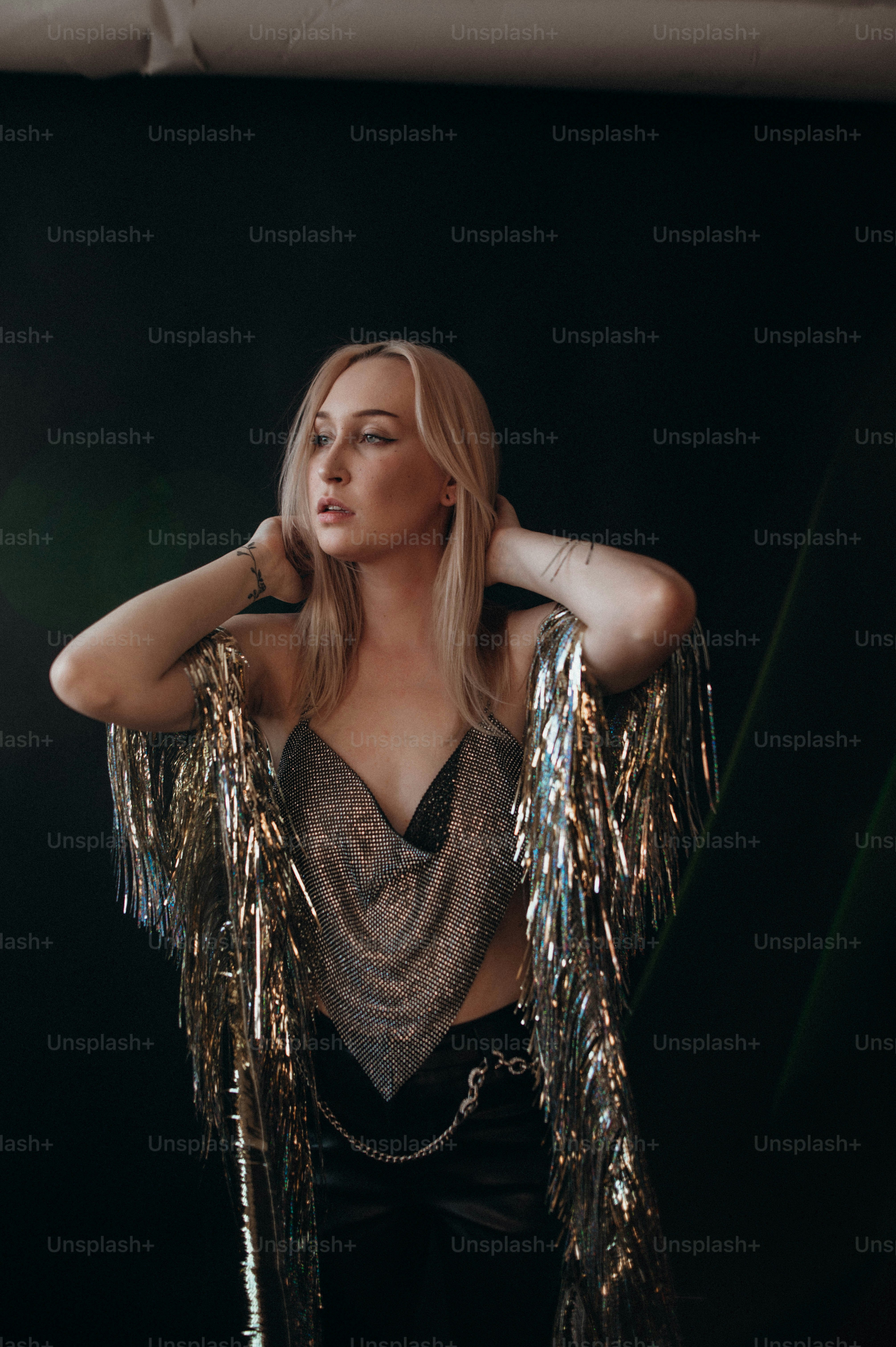 a woman in a silver top with gold sequins