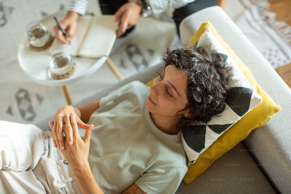 Une femme assise sur un canapé tenant un verre de vin