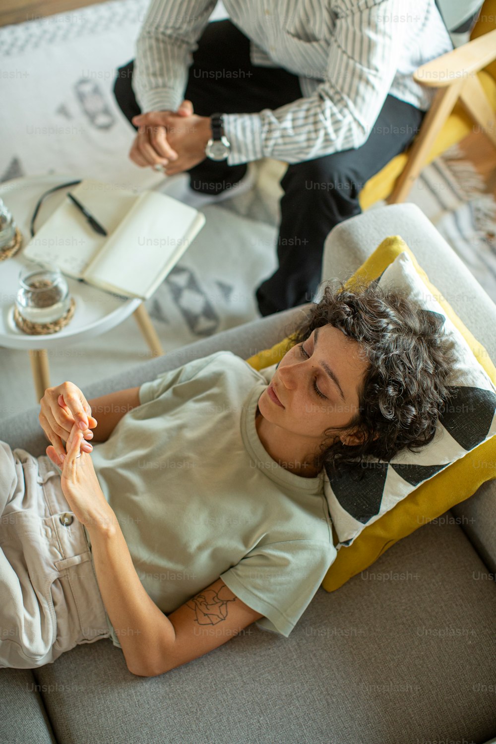 a woman laying on top of a couch next to a man