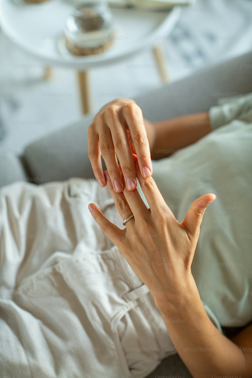 a woman laying on a bed holding her hand up