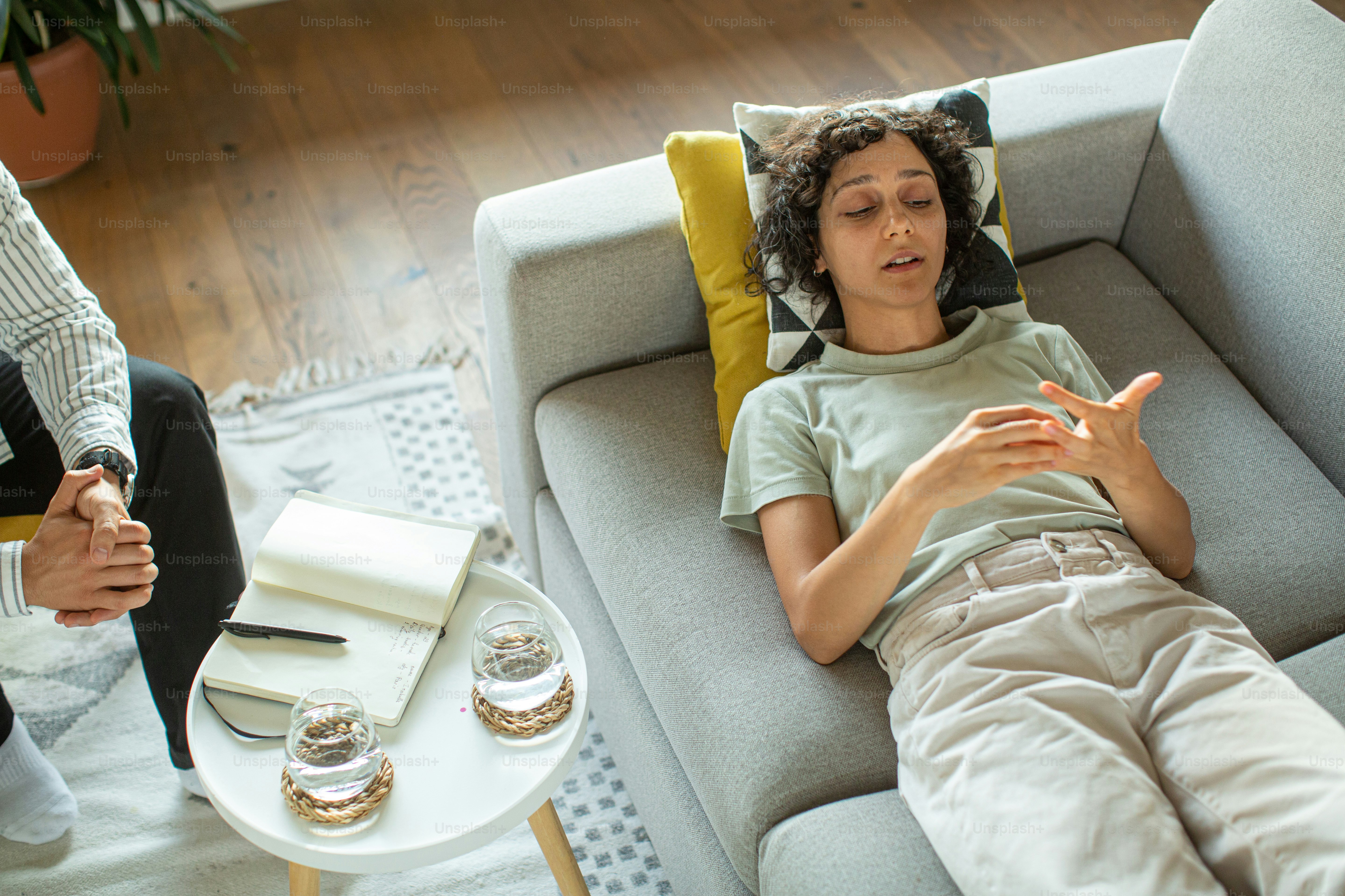 a man laying on top of a couch next to a table