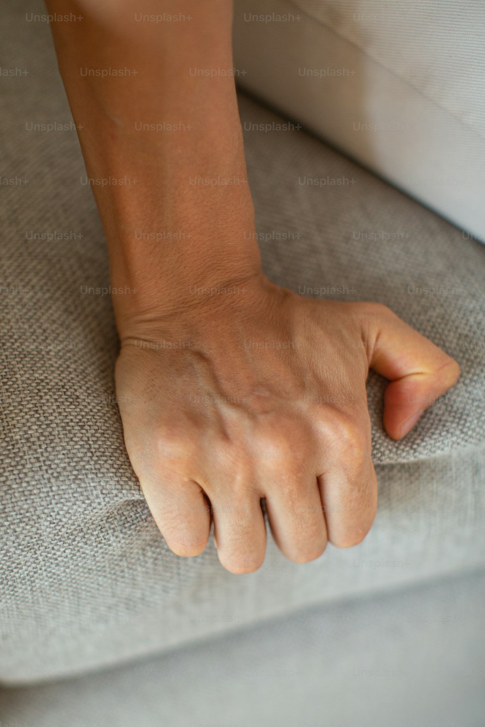 a close up of a person's hand on a couch