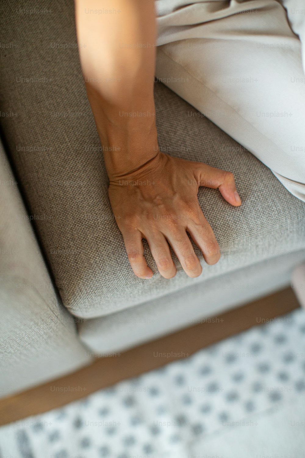a person sitting on a couch with their hand on the back of the couch