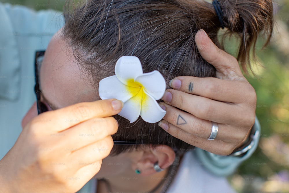 a woman putting a flower on her hair