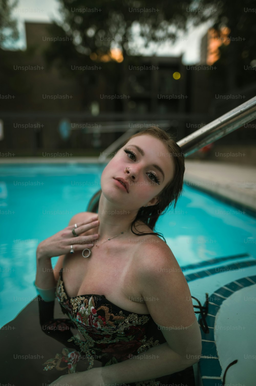 a woman sitting in a pool with a cigarette in her hand