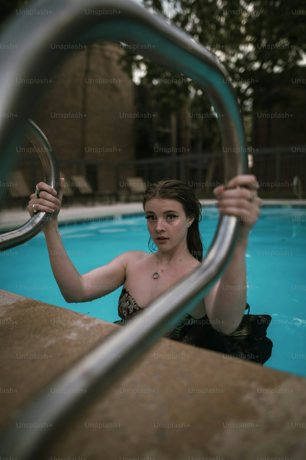 a woman in a swim suit holding onto a metal bar